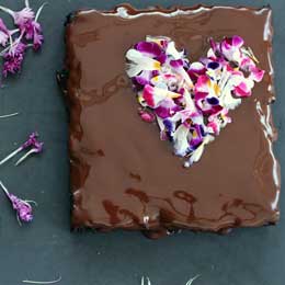 ハート型にエディブルフラワーをあしらったエレガントなバレンタインのチョコレートケーキ。バレンタインパーティーのデザートにも最適